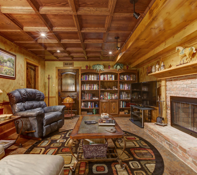 cozy man cave with small library and leather recliner