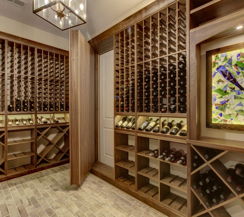 wine storage area with artwork and chandelier