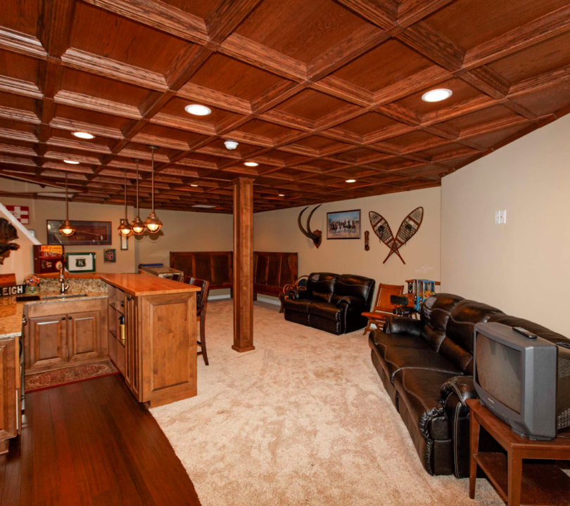 basement with wood panel cieling and bar area