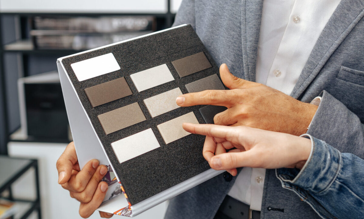 Salesman shows color swatches to lady customer for new kitchen furniture aging in place remodeling